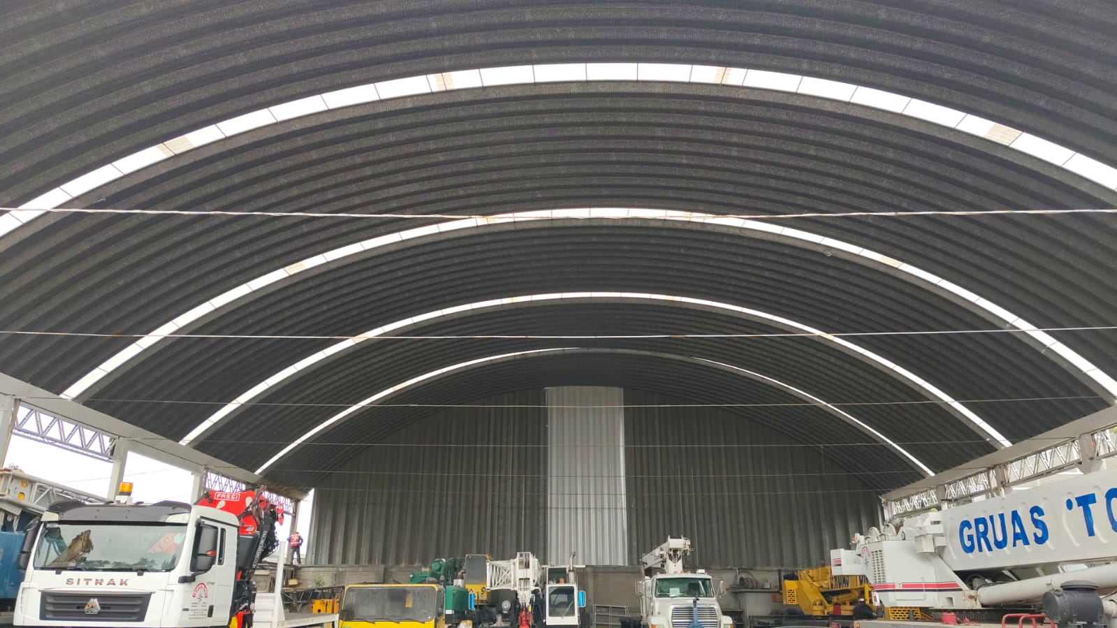 Interior de nave industrial con arcotecho usada como base de maquinaria pesada